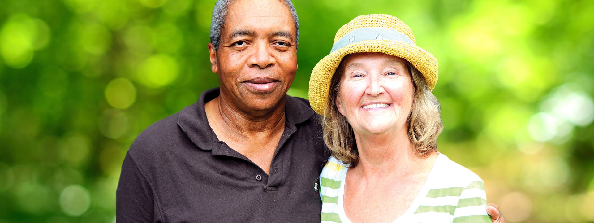 Smiling African American man and white woman blurry green background