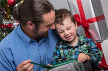 Father and young son unwrapping Christmas gifts