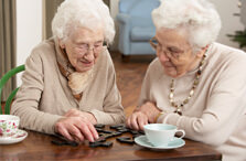 Two senior women playing dominoes