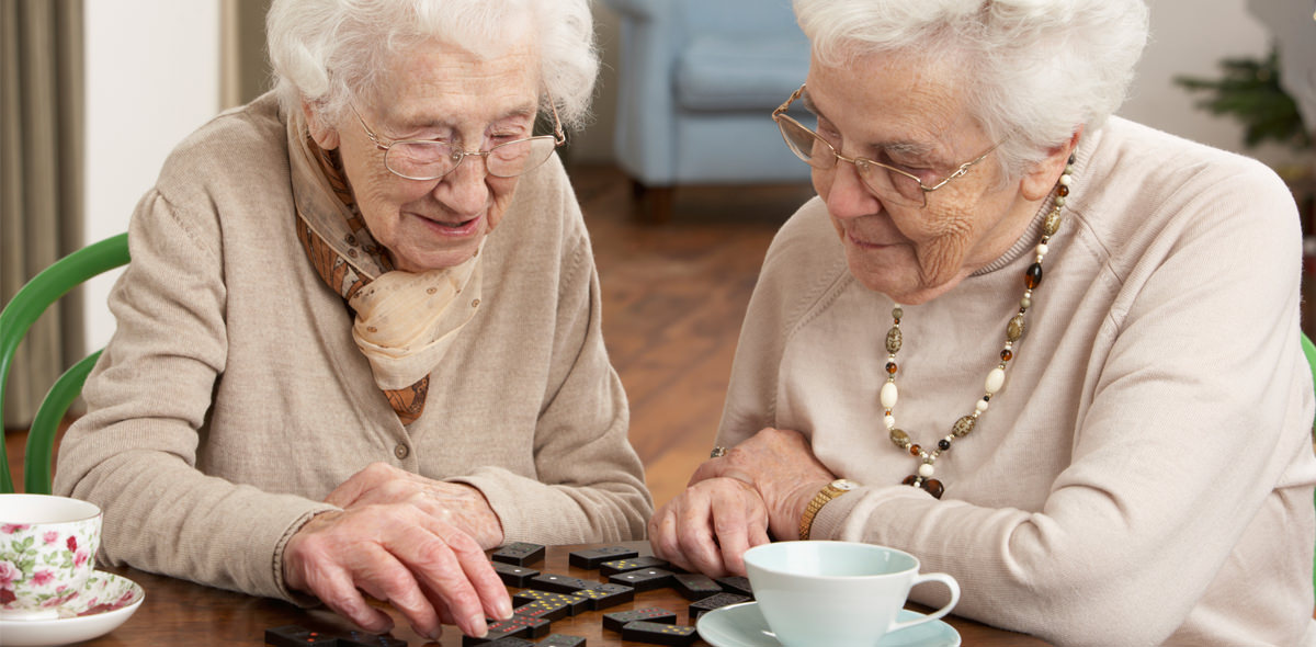 Two elderly women playing dominoes