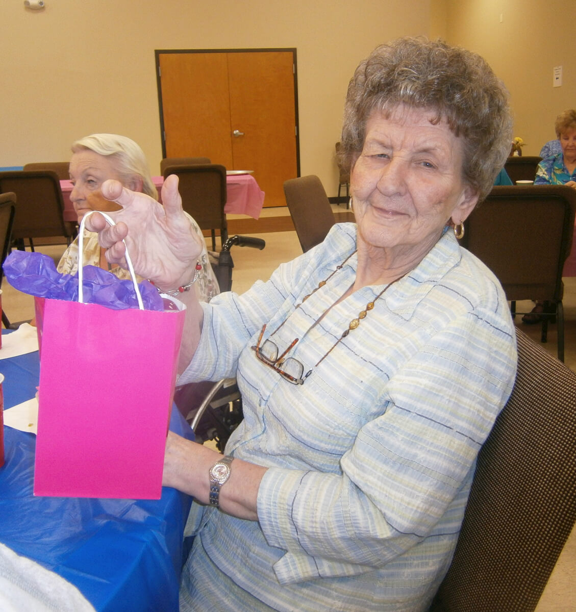 Heath House resident Betty Graham receives a present at the 2nd Annual Magical Birthday Party