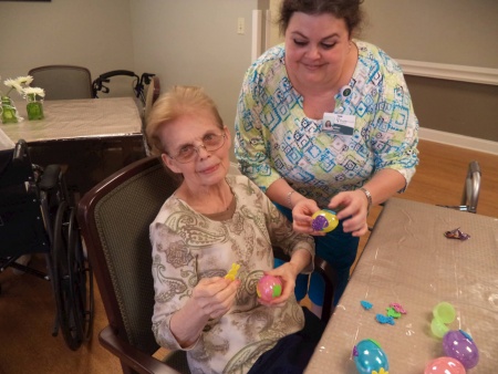 volunteer Missy McClain stuffing Easter Eggs with resident Mamie Palmquist.