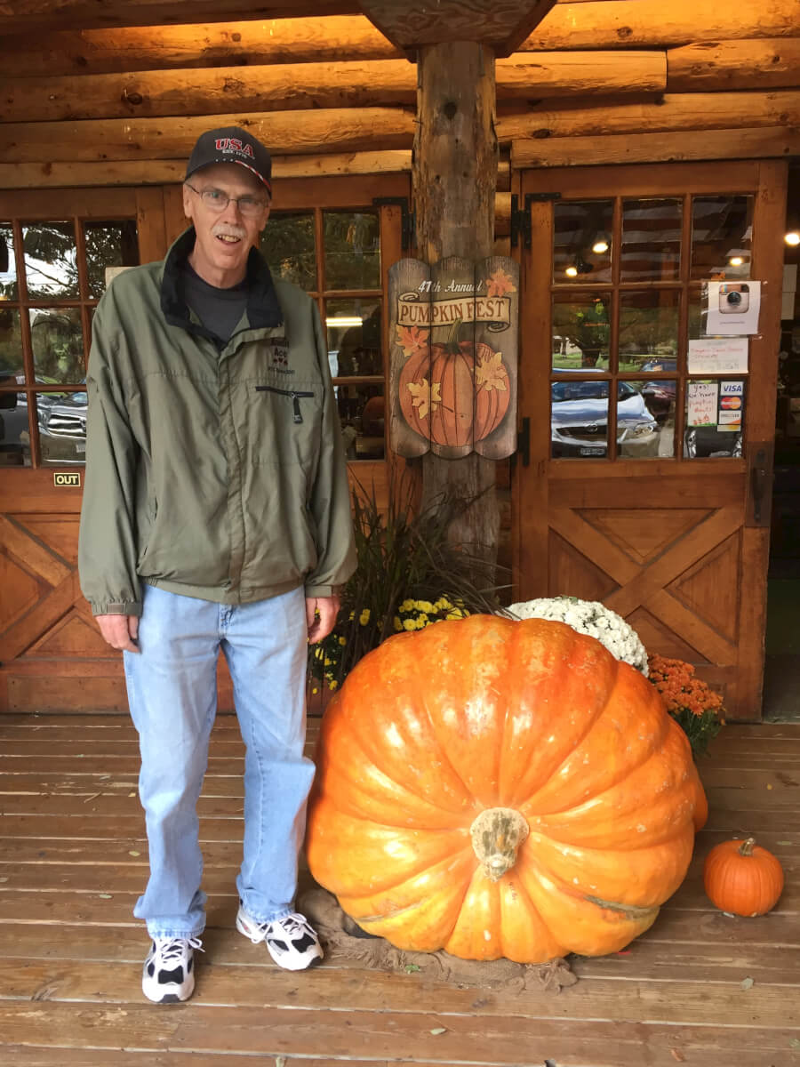 Woodcrest Commons resident Tom Armstrong posing with a big pumpkin 
