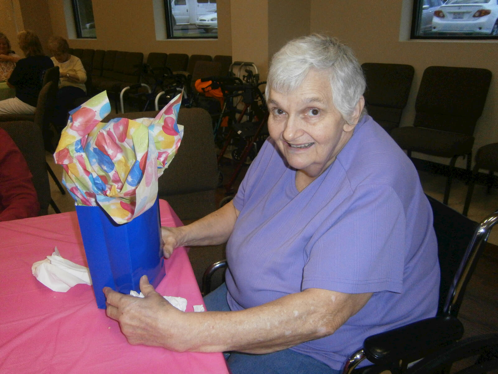 Wexford House resident Glenda McFalls receives a present at the 2nd Annual Magical Birthday Party