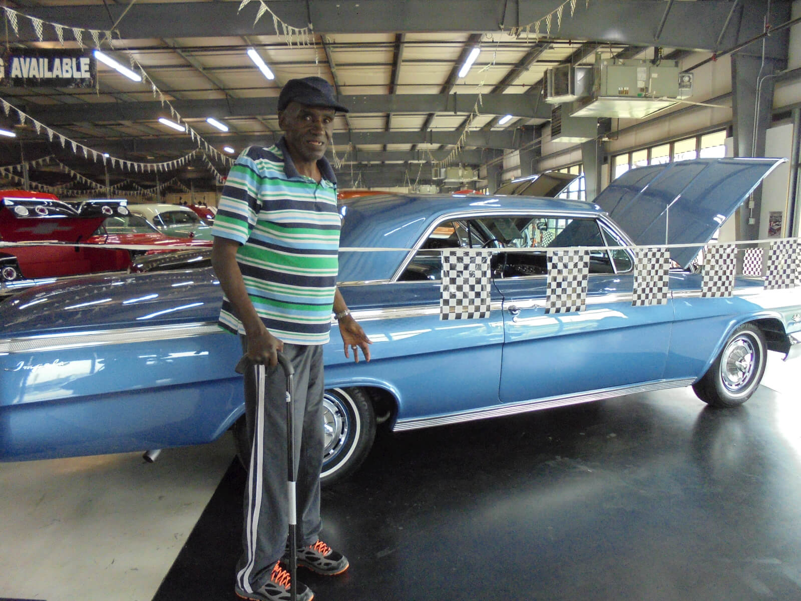 Oakview Commons resident Johnny Baldwin posing with a classic car
