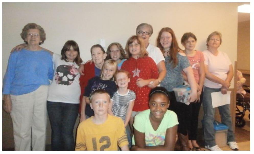 Twelve Oaks residents Iva Scott and Faye Bryant pose with the Children in Action volunteers (front row, left to right) Reece, Chloe, Samera, Kyia, (back row, left to right) McKenzie, Abigail, Kiara, Jan, Sidney, Miranda and group leader Wanda Bowman