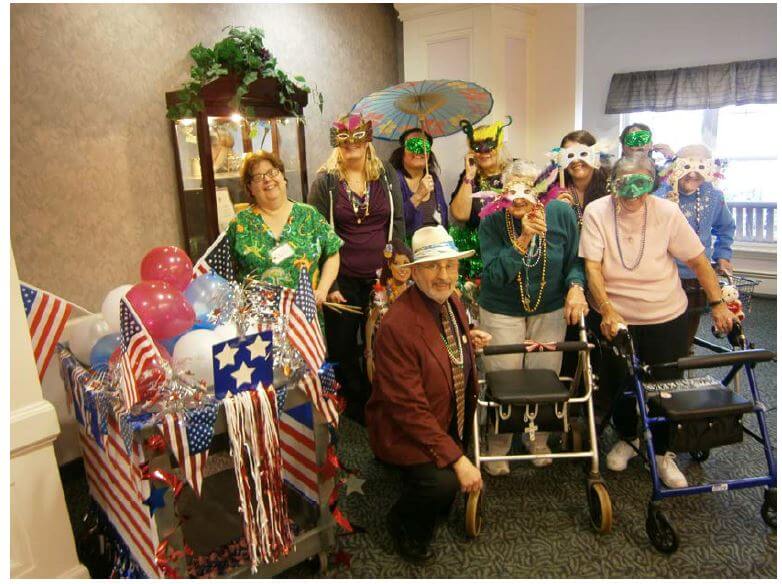 Pictured here during the Mardi Gras parade are Glenwell residents and staff (back row, left to right) Team Leader Donna Jonak, Director of Resident Care Lynn Harmening, Administrator Amy Hayward, Administrative Assistant Sue Freshwater, Activities Leader Amanda Tobin, Assisted Living Nurse Christine Pazian, resident Marcella Olson, (front row, left to right) Dietary Director Fran Roselli and residents Sarah Kriegbaum and Shirley Hanes.
