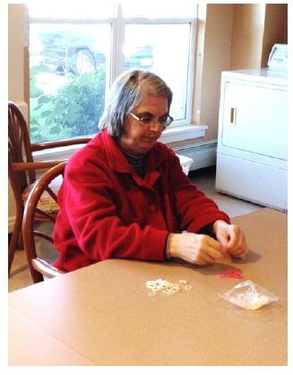 Woodcrest Commons resident Rosanne Bourne works on making bracelets and necklaces