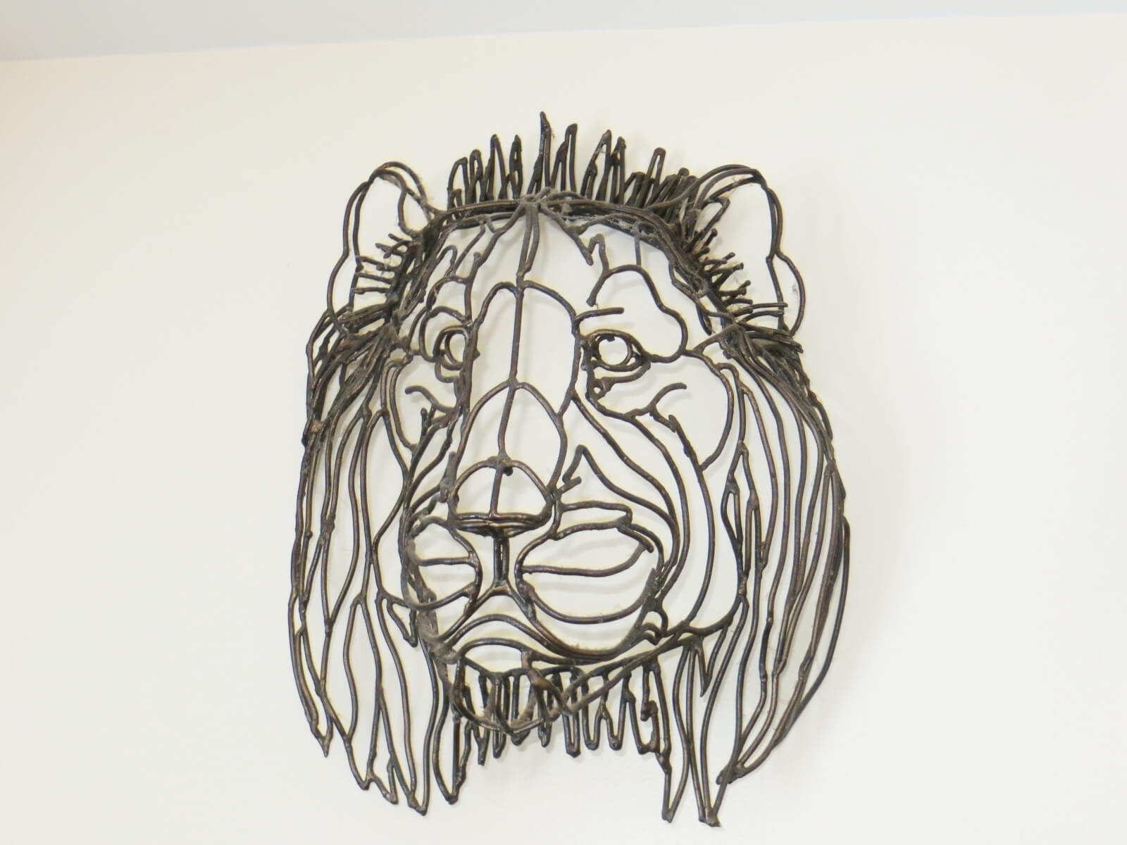 Peter's Metal Lion Head art piece hanging on a wall 