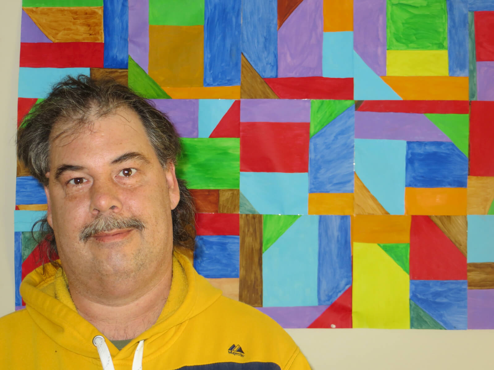 Photo of Peter in front of colorful artwork 