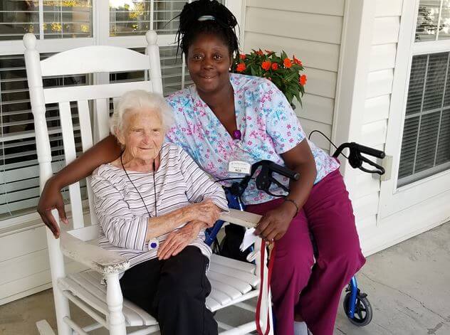 on the porch at Pee Dee Gardens is resident Virginia Hudson and Pee Dee Gardens’ Resident Care Director Tuwanna James