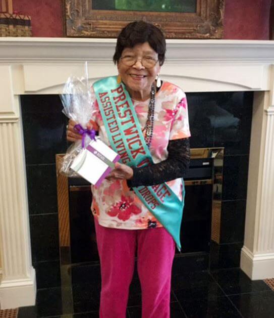 A resident from Prestwick Village holding a love drop basket 