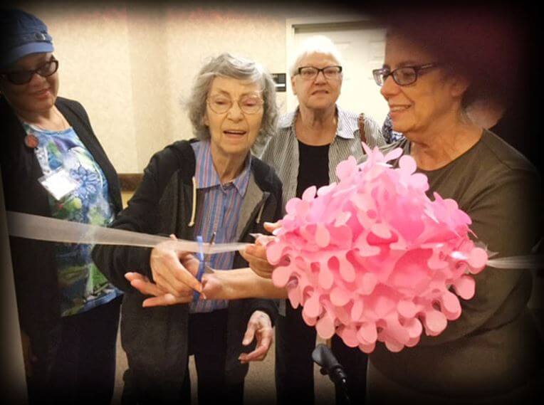 June Benson celebrates her move into Prestwick Village by cutting a ribbon into her room 