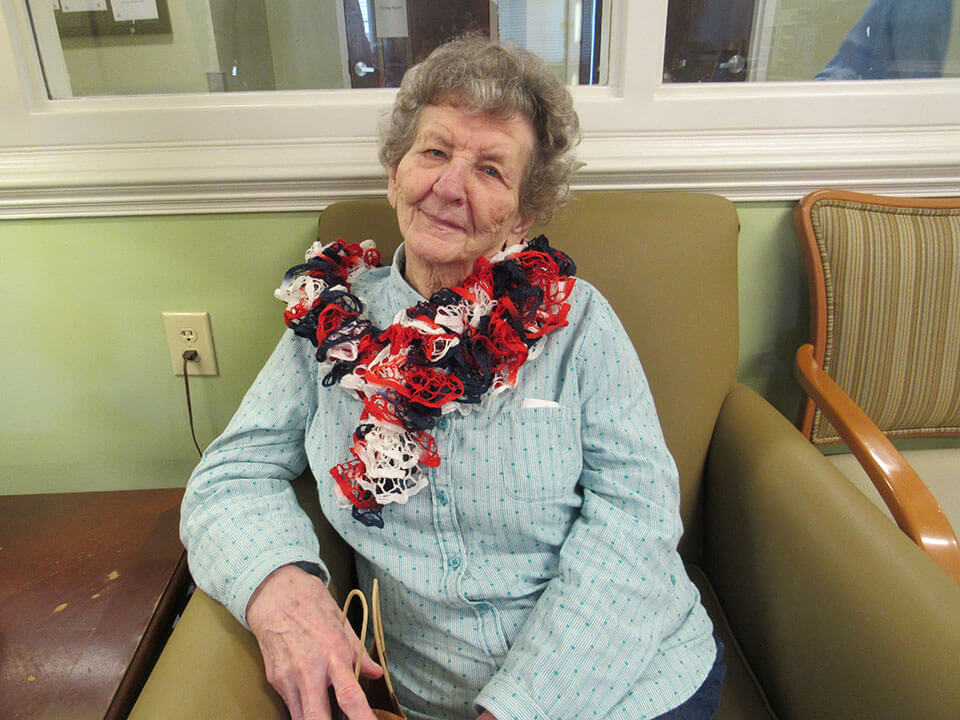 Elderly female resident wearing handmade scarf