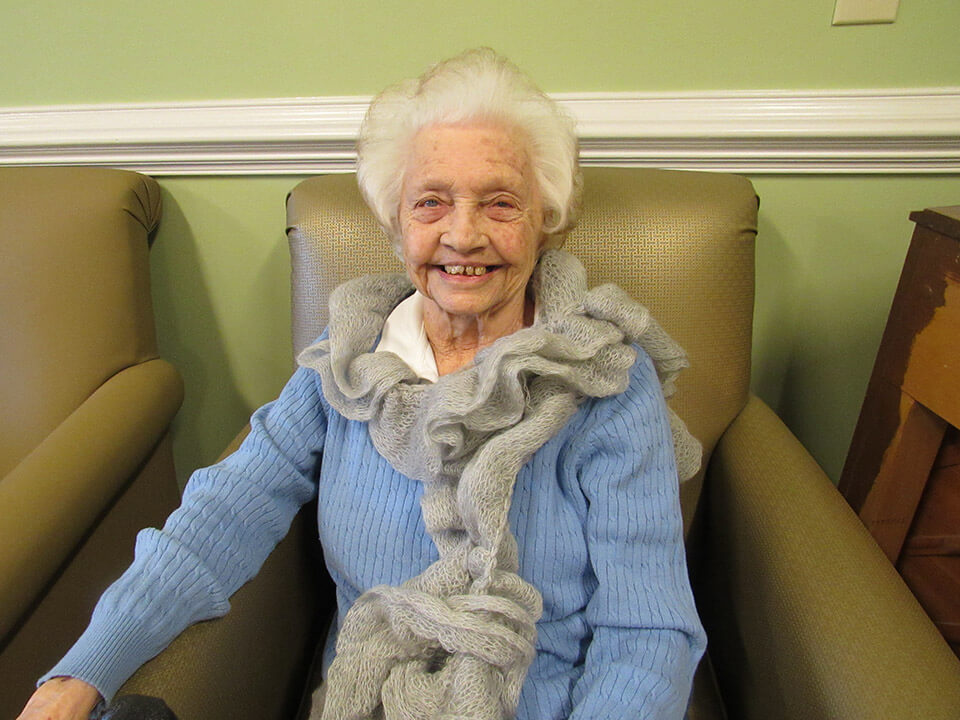 Elderly female resident wearing homemade scarf