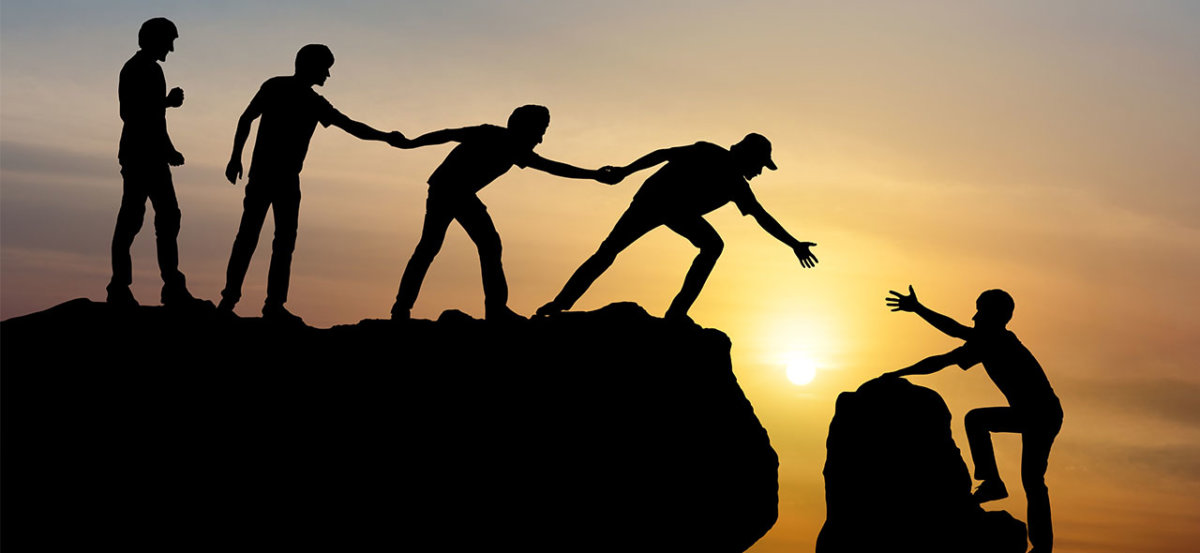 People holding hands during sunset to help each other