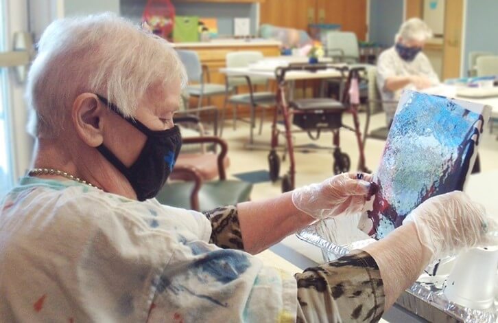 Ruth DePaul works on a paint pouring craft