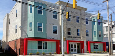 Front of apartment building with tan, green and red accents