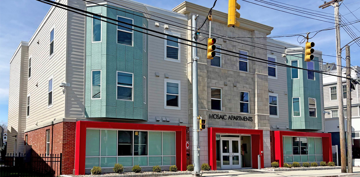 Front of apartment building with tan, green and red accents