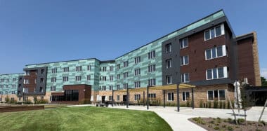 Green and brown exterior of building with blue sky