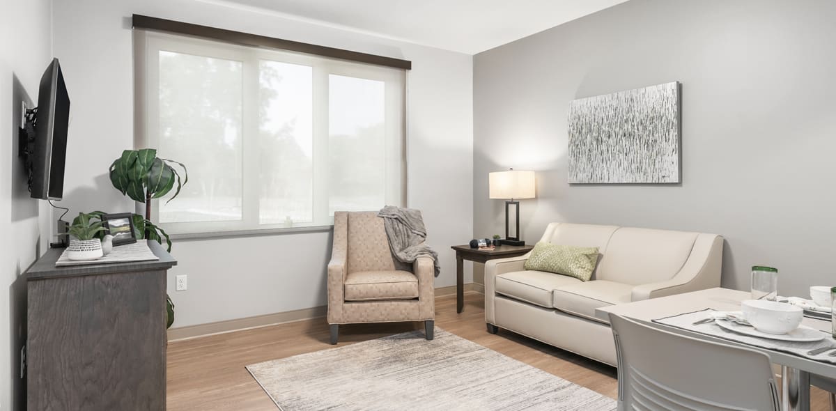Living room with television, chair, couch, and artwork on the walls