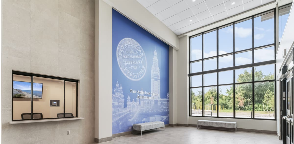 Building lobby with large windows and a blue and white mural