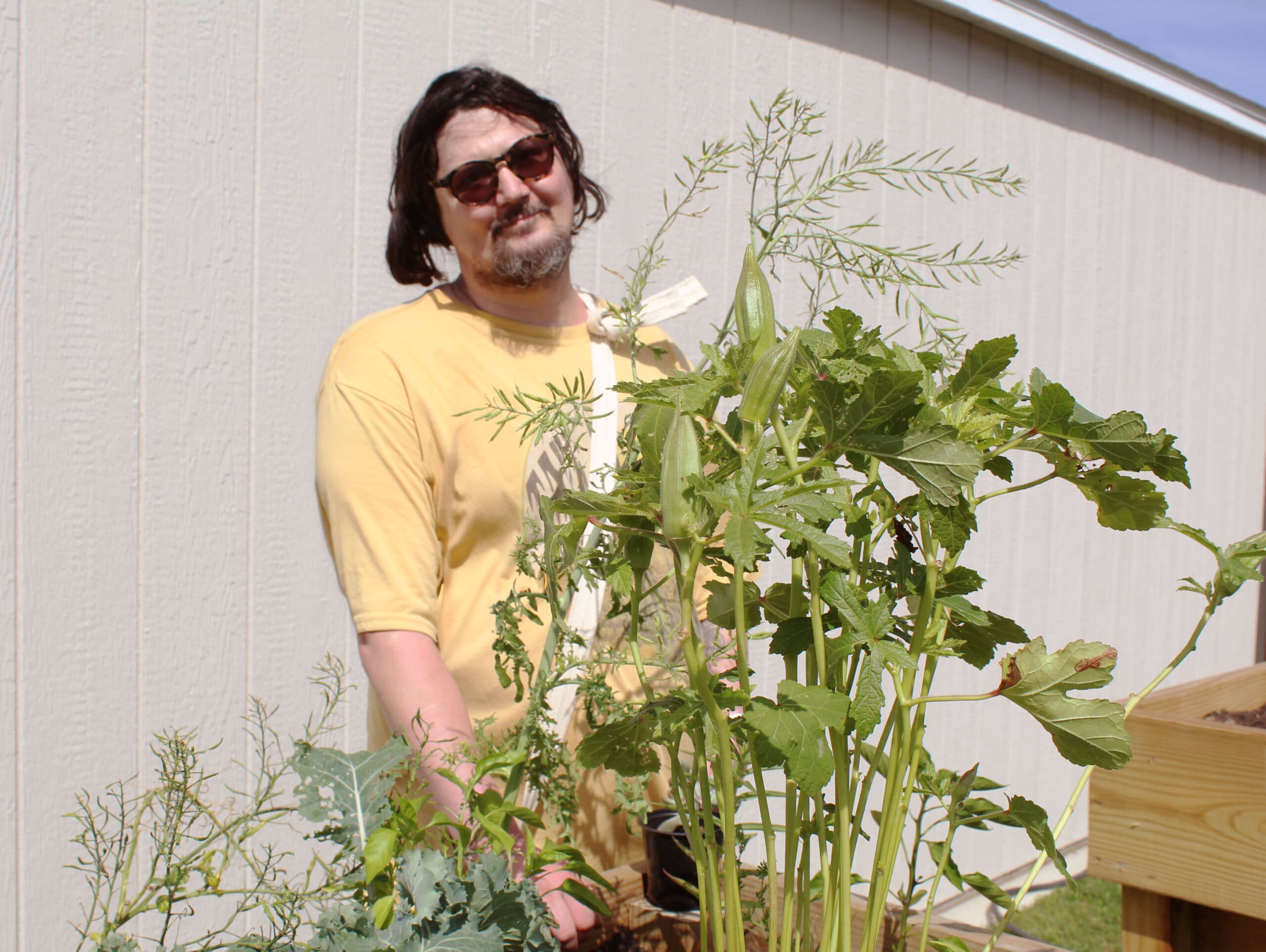 Garden in foreground; person in background wearing glasses