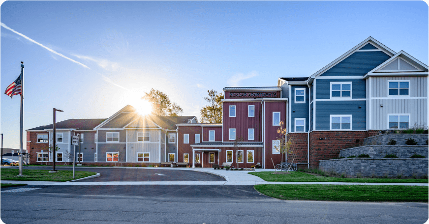 Red, tan and blue building. American flag on left. Sun spot toward center.