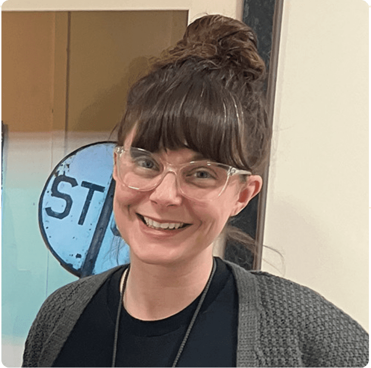 Woman wearing glasses. with brown hair and bun.