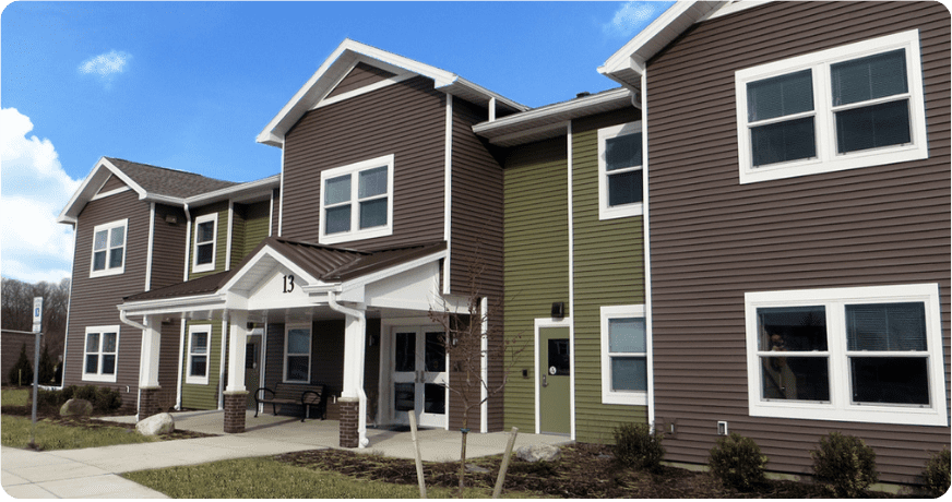 Green and gray building with blue sky.