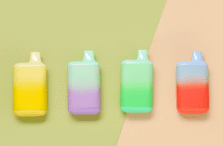 Four pastel-colored vape devices with gradient hues (yellow, purple, green, and red) are arranged side by side on a background split diagonally between light green and peach.