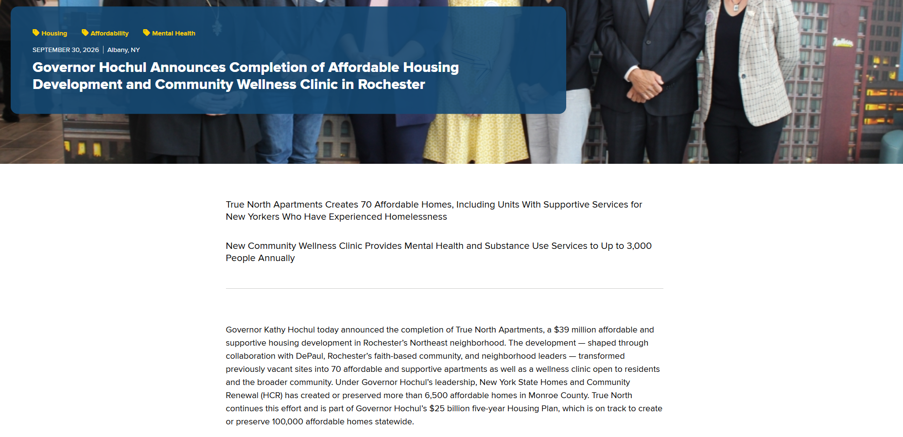 Screenshot of a news article announcing Governor Hochul's completion of affordable housing and a wellness clinic in Rochester, with a blue and yellow headline and text describing the project details below.